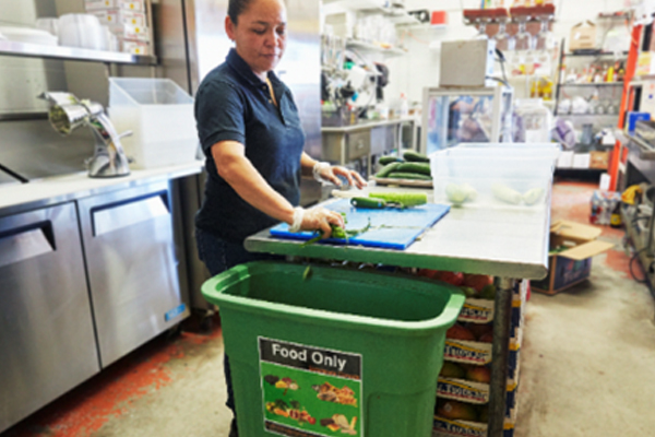 Woman putting food scraps into a compost bin