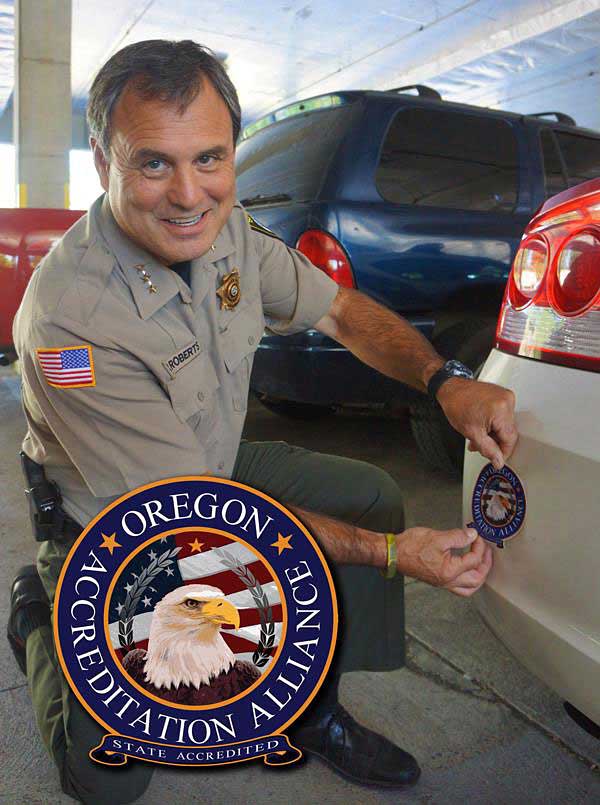 Sheriff Roberts applies an accreditation sticker to a patrol car