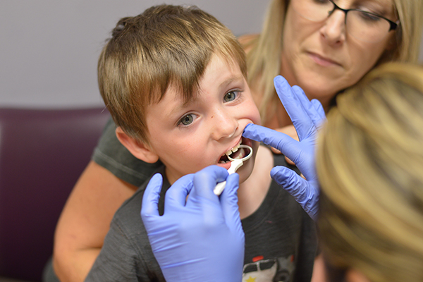 Little boy getting his teeth checked at the dentist.