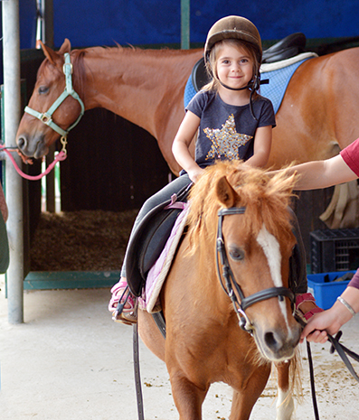 girl riding horse at fairgrounds