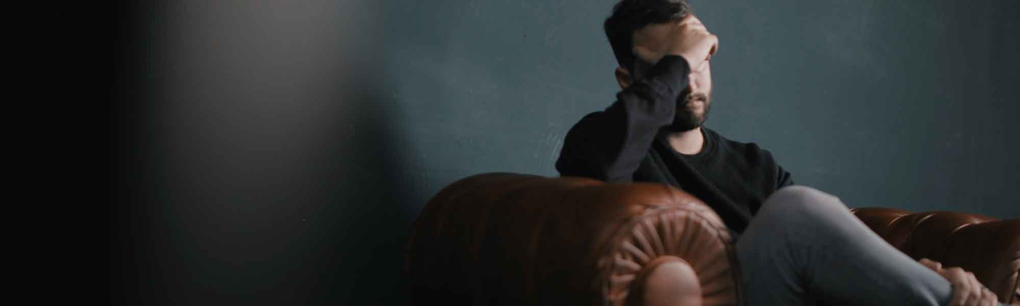 Depressed man sitting on couch