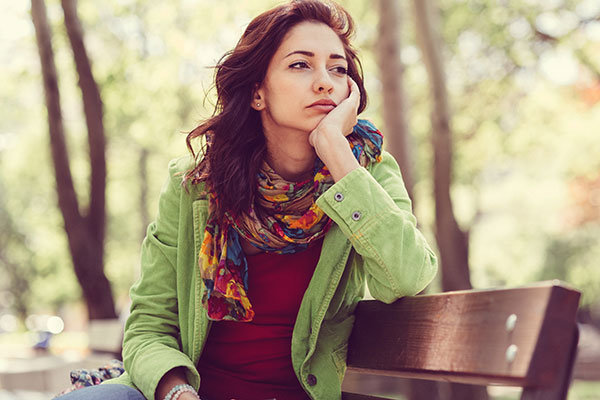 Woman on park bench feeling alone