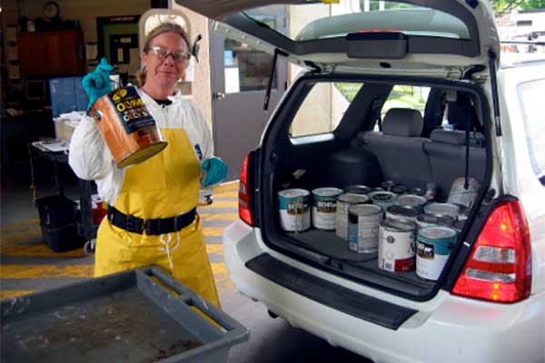 woman removes hazardous waste from car