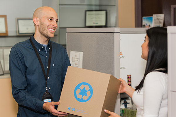 Man handing woman recycling supplies