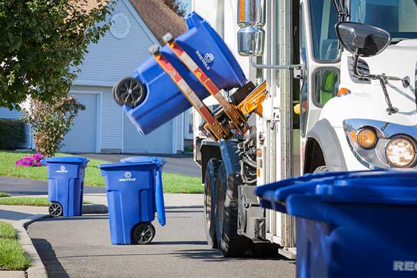 Garbage truck picking up bins