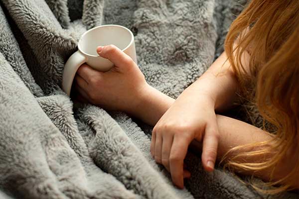 Woman wrapped up in blankets