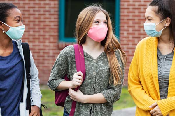 Three young students wearing masks.