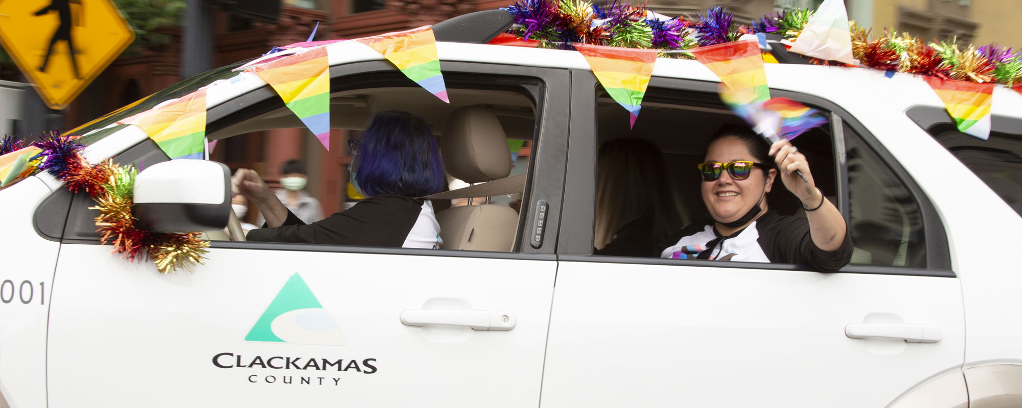 People riding in a car in the pride parade