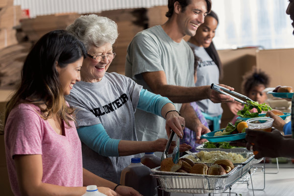 Team of volunteers serve food at shelter