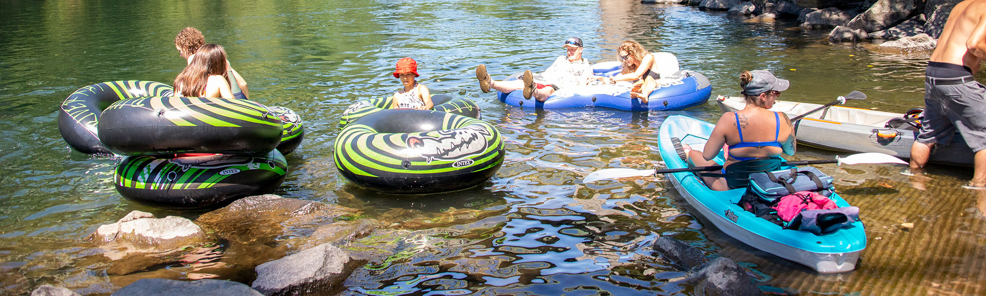 Kayakers and floaters in the river at Barton Park