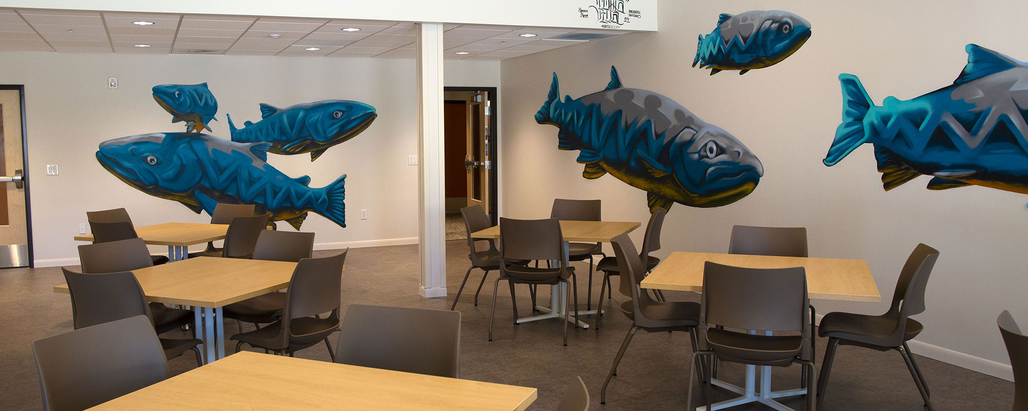 Dining room at Tukwila Springs - paintings swimming salmon decorate the walls