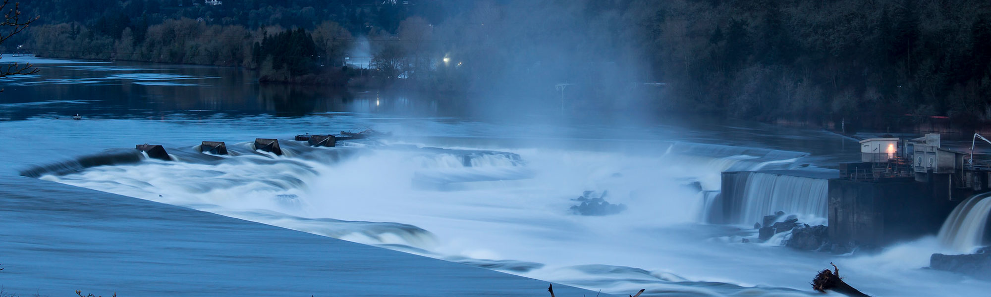 Willamette falls at dusk with moon visible and mist