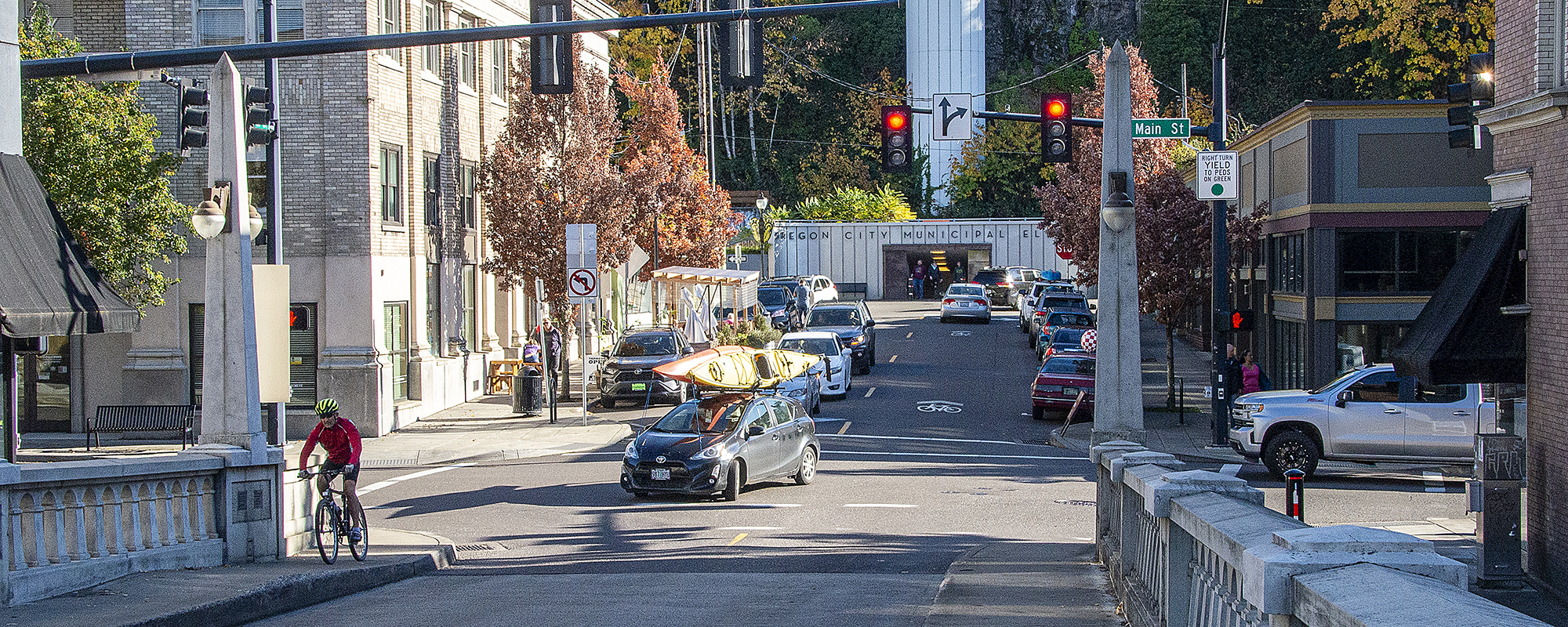 arch bridge with people driving and biking on Main Street