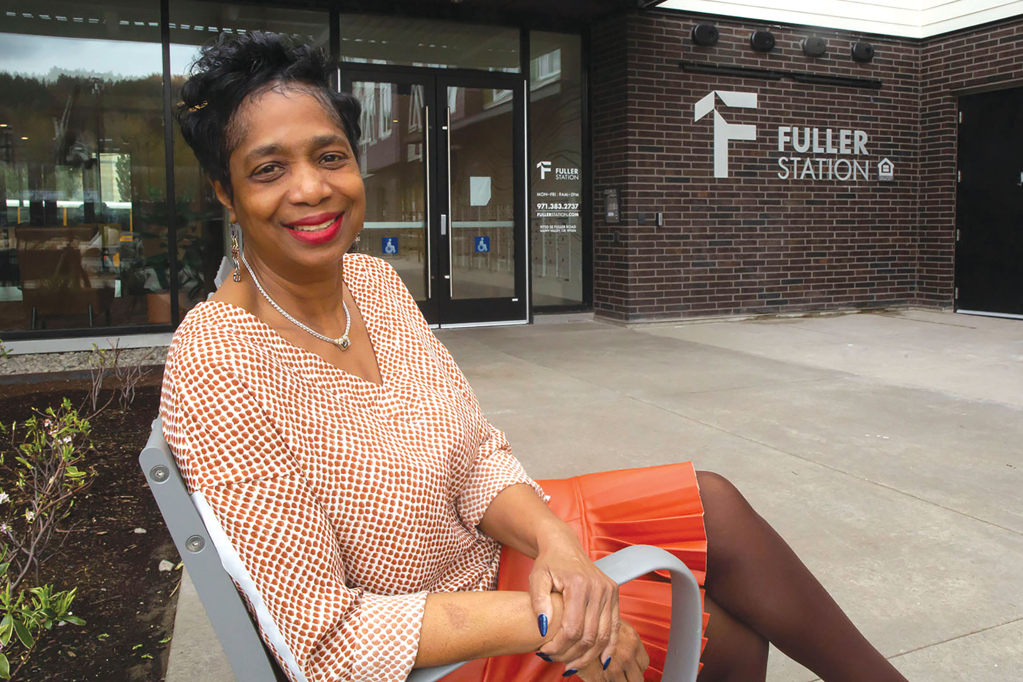 Helen Johnson sitting on a bench in front of Fuller Station