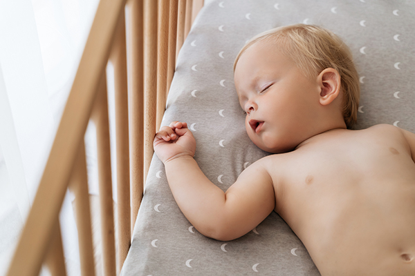 Baby sleeping in a safety-approved crib