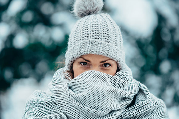 Woman with winter hat on and scarf covering her face
