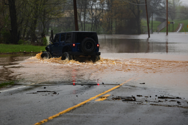 vehicle attempting to drive through closed road that is flooded