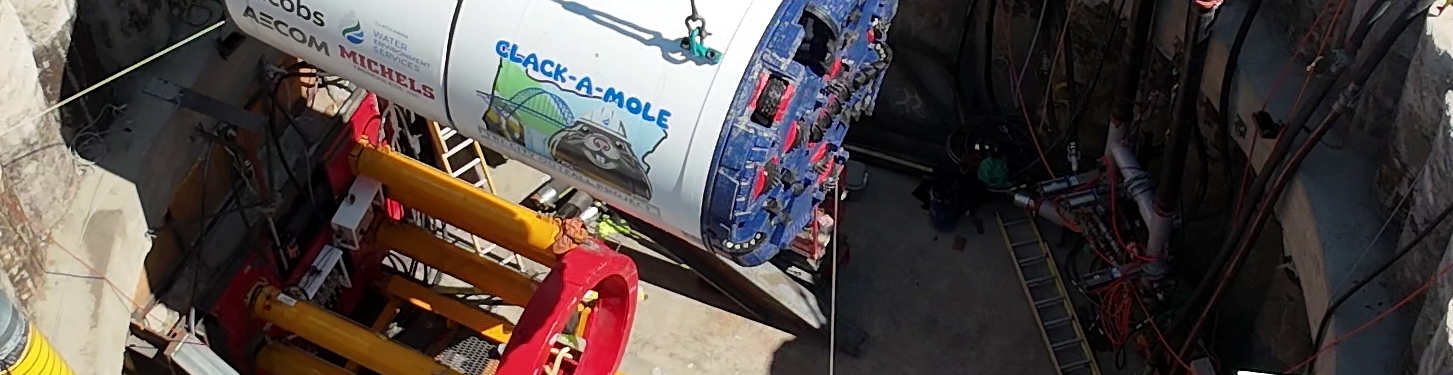 crane lowering large tunnel drilling device called 'clack-a-mole' 