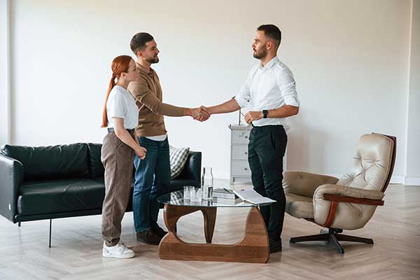 couple shaking hands with another man
