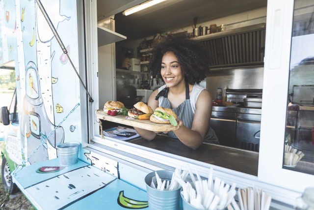 women serving food from a food cart