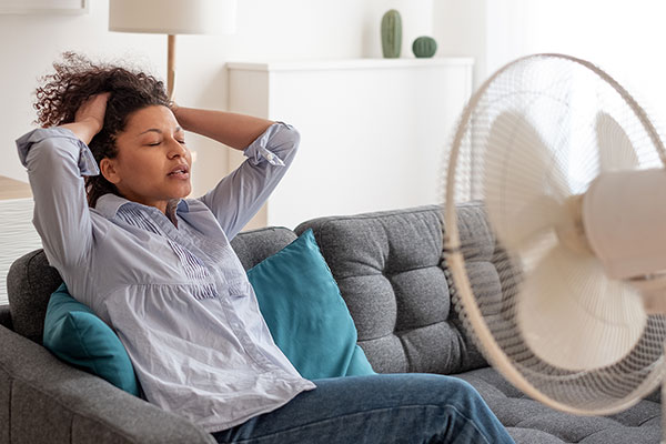 Woman cooling herself in front of fan