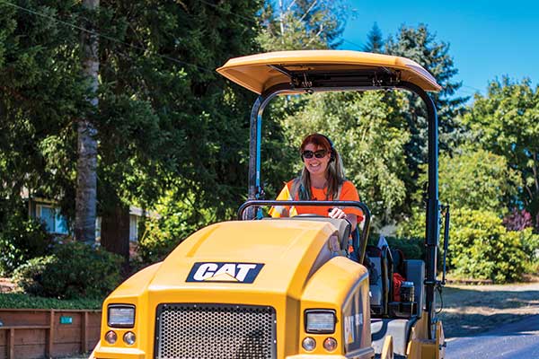 woman operating paving equipment