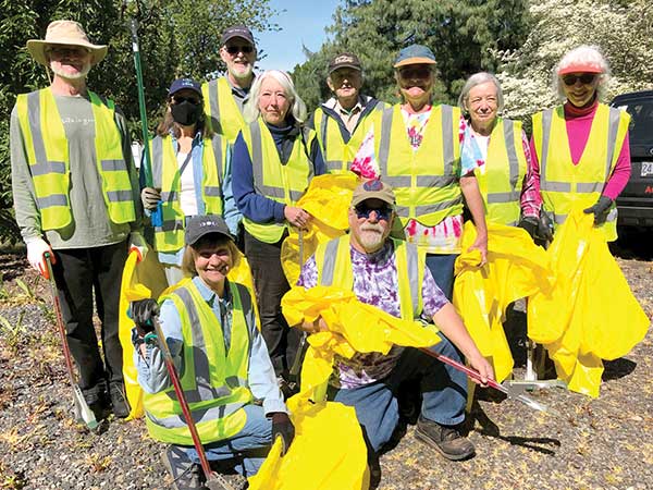Cleanup volunteers posing together with their safety vests on