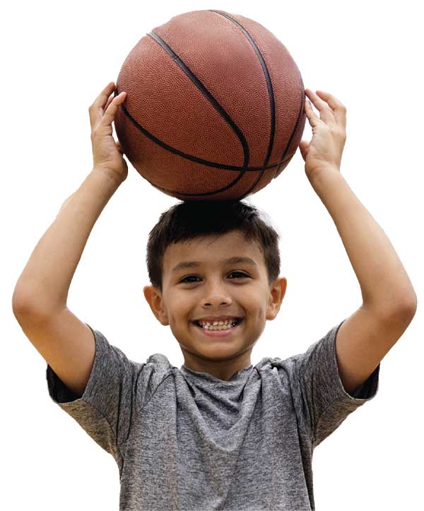 Boy holding basketball over head, smiling