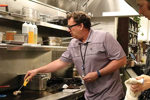 instpector measuring temperature in kitchen