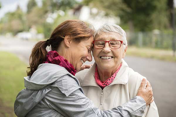 Mother and adult daughter sharing a smiling embrace