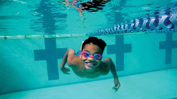 Child underwater swimming with goggles on