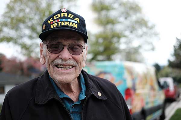 Man in sunglasses smiling in Korea Veteran hat