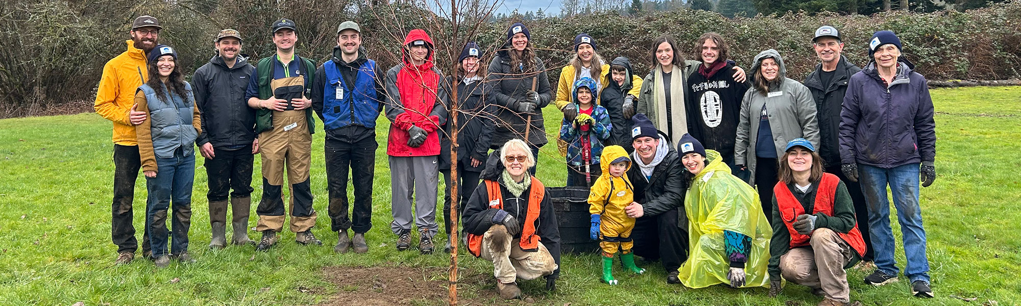 Friends of Trees in front of a sapling