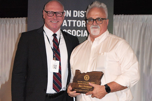 Bill Stewart holding his award, standing next to John Wentworth