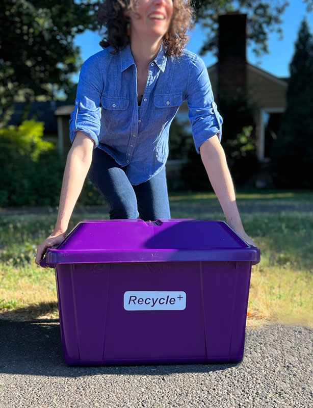 Woman holding a Recycle+ bin