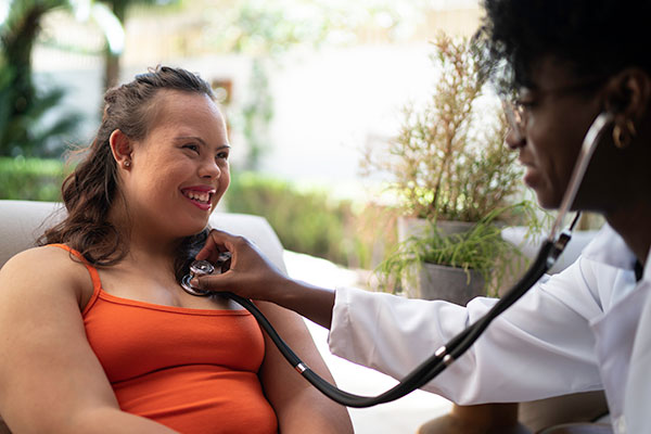 Girl with Down Syndrome being examined by a nurse