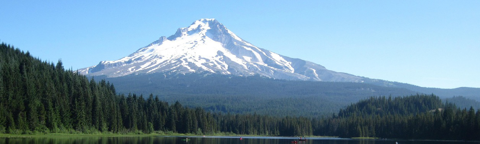 Lake surrounded by trees with Mt. Hood in the distance.