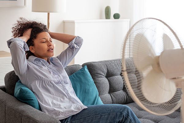 Woman sitting in front of fan