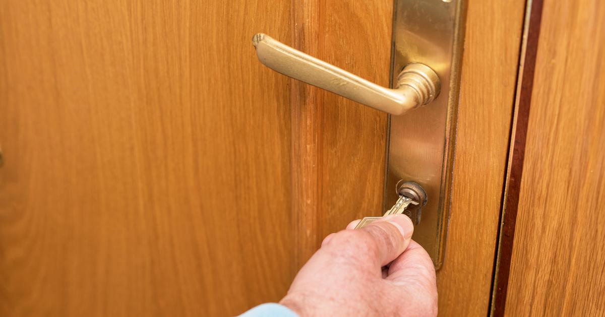 Senior man unlocks door