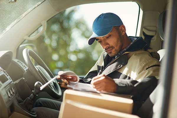 Man signing forms in car