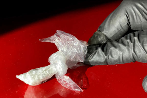 White powder in a bag on the hood of a card