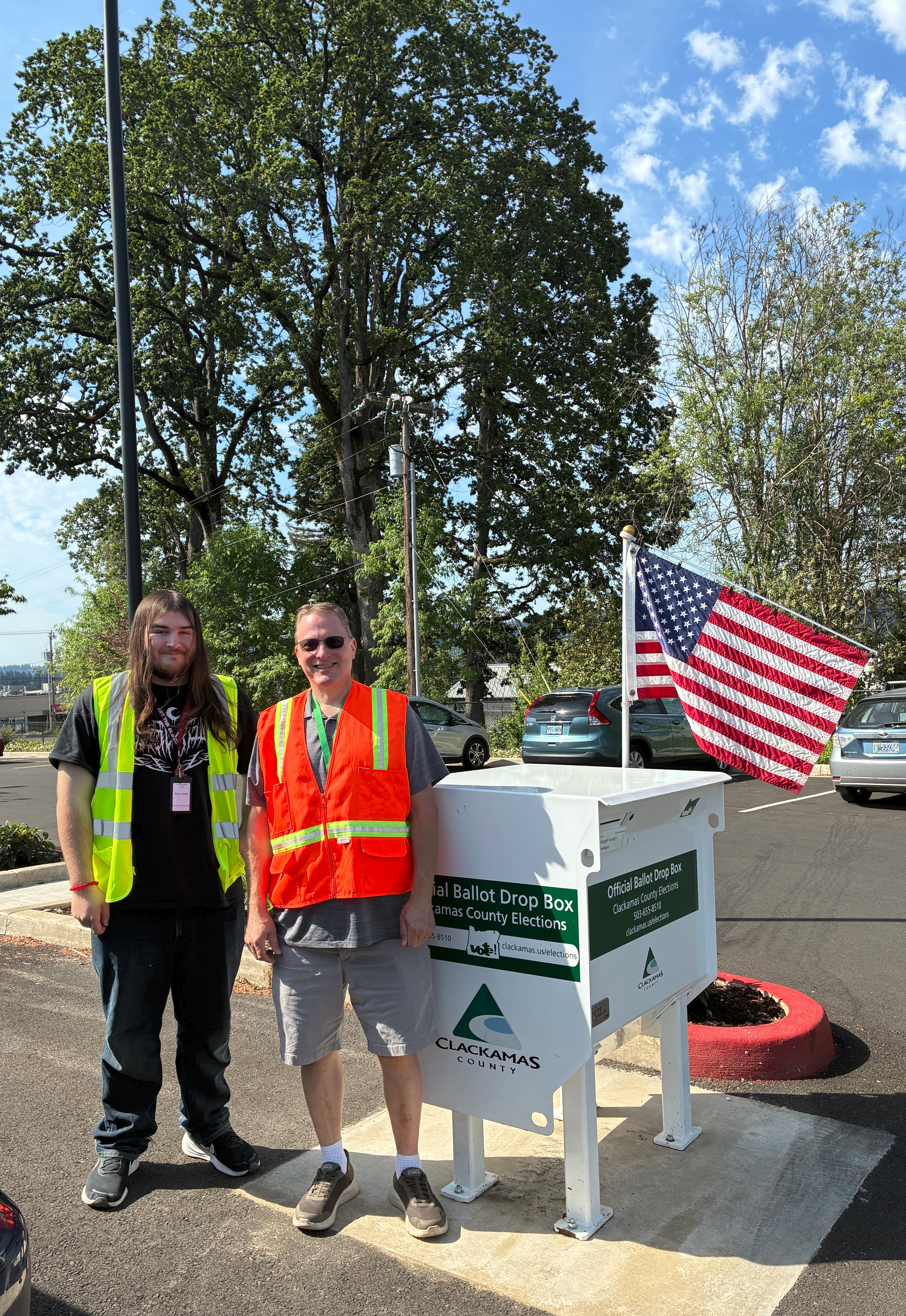Election worker team stands at the Oak Lodge Library Drop Site