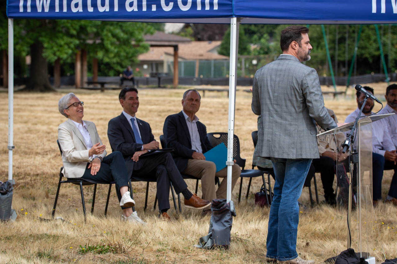 Clackamas County Commissioner Ben West speaks behind a lectern at the Clackamas County Recovery Campus groundbreaking on July 29, 2026. Governor Tina Kotek, Oregon Senate President Rob Wagner, and Clackamas County Chair Craig Roberts are seated in the background.