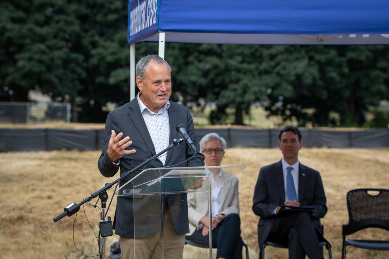 Clackamas County Chair Craig Roberts speaks behind a lectern at the Clackamas County Recovery Campus groundbreaking on July 29, 2026. Governor Tina Kotek and Oregon Senate President Rob Wagner are seated in the background.