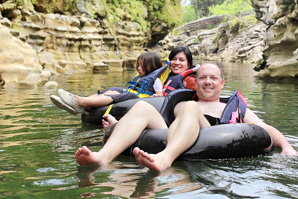 Family floating down the river wearing life jackets