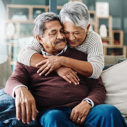 Senior couple hugging on the couch