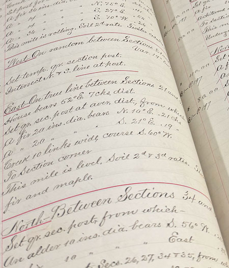 Close up view of recordkeeping books of surveyor notes handwritten in cursive.