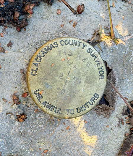 Brass disk representing a Clackamas County public land corner monument.