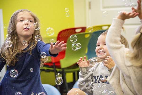 Children play with bubbles at storytime event