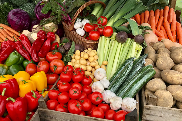 A assortment of fresh vegetables for sale on a market stand.